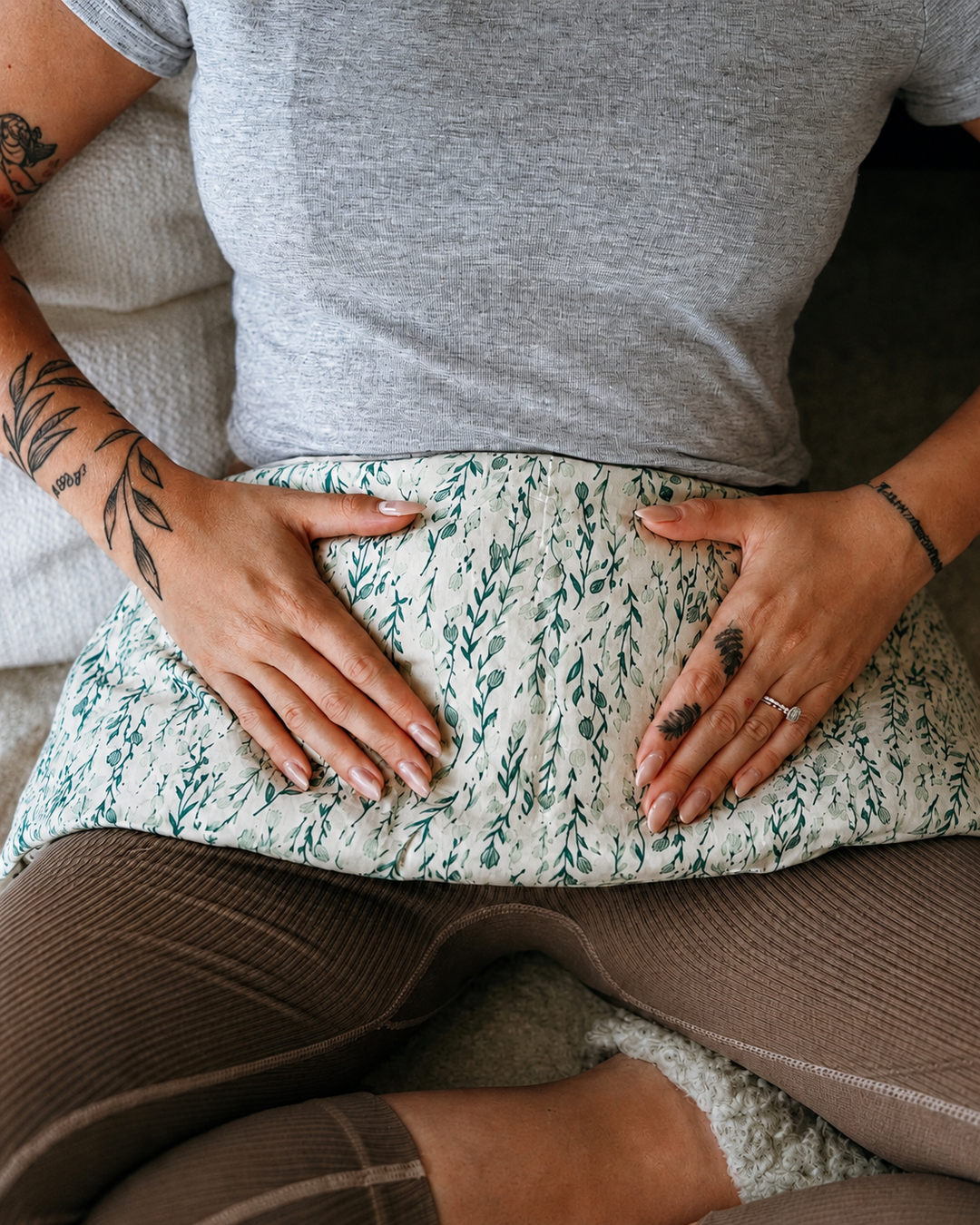 Seagrass weighted body wrap with green botanical print resting on lap